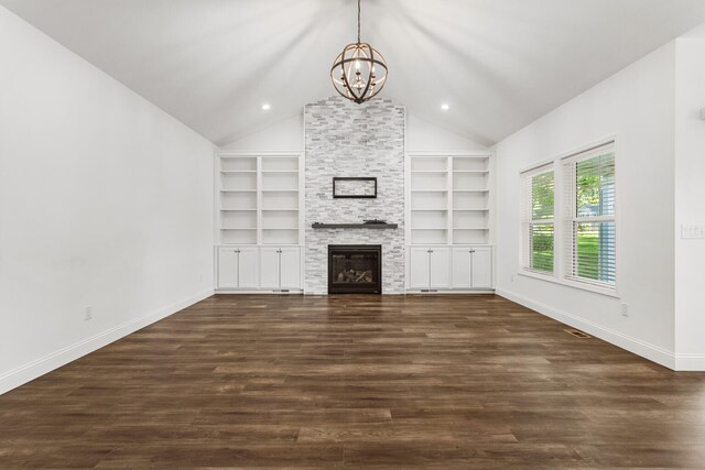 unfurnished living room featuring a chandelier, built in shelves, baseboards, dark wood-style floors, and vaulted ceiling
