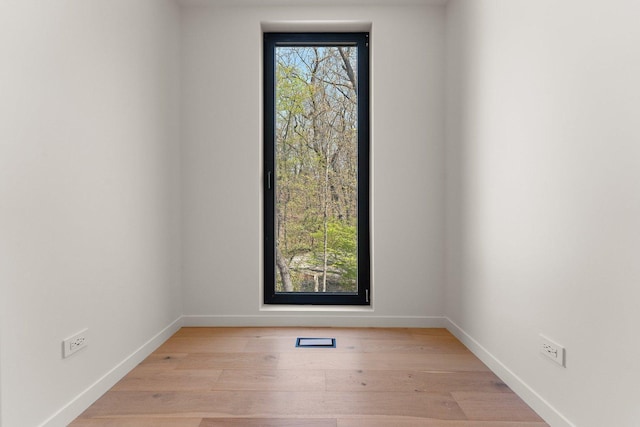spare room featuring baseboards and light wood-type flooring