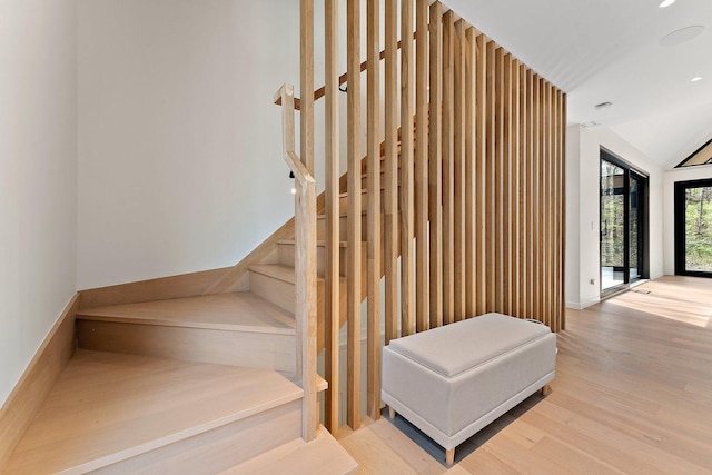 stairs with wood finished floors, lofted ceiling, and recessed lighting