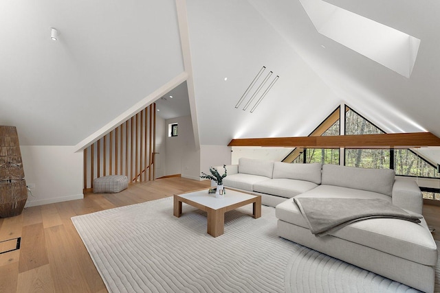 living room featuring wood finished floors, lofted ceiling, and baseboards