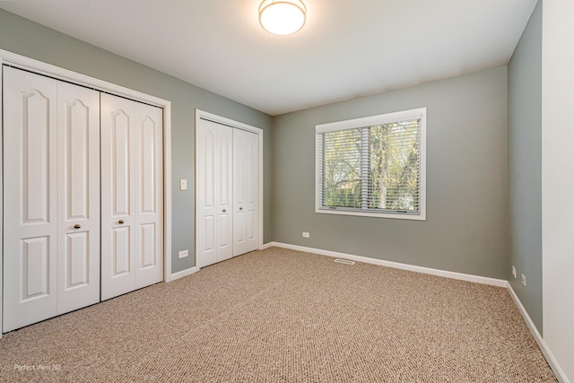 573 W Babcock Ave, Elmhurst, IL 60126 - unfurnished bedroom featuring two closets, carpet floors, and baseboards