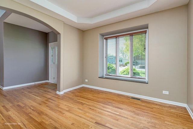 573 W Babcock Ave, Elmhurst, IL 60126 - spare room with arched walkways, light wood-style flooring, a raised ceiling, and baseboards