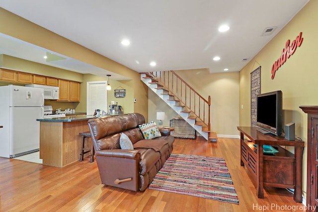 living area featuring recessed lighting, visible vents, stairway, and light wood-style floors