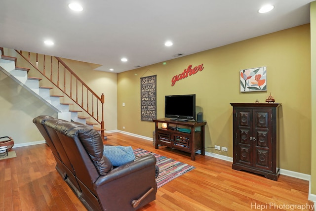 living area with baseboards, stairs, and wood finished floors