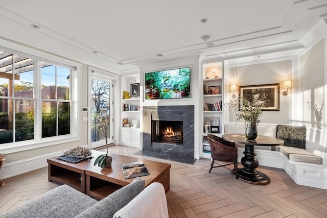 living area with recessed lighting, a high end fireplace, and built in shelves