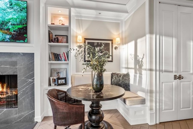 sitting room featuring built in shelves and a premium fireplace
