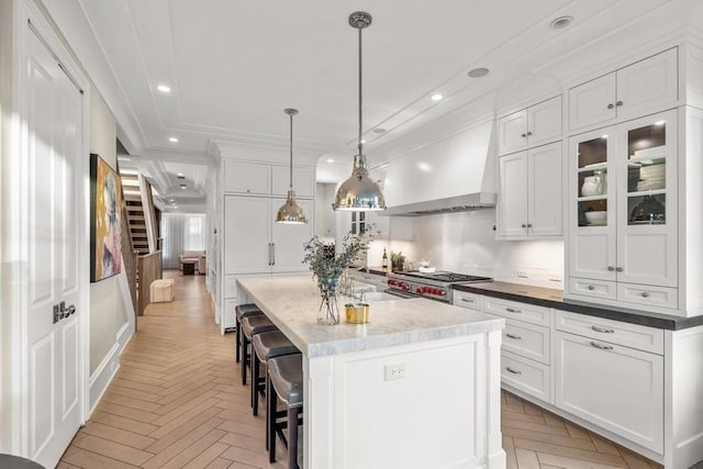 kitchen with white cabinets, recessed lighting, and premium range hood