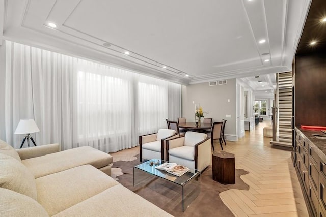 living room featuring recessed lighting, baseboards, visible vents, and a raised ceiling