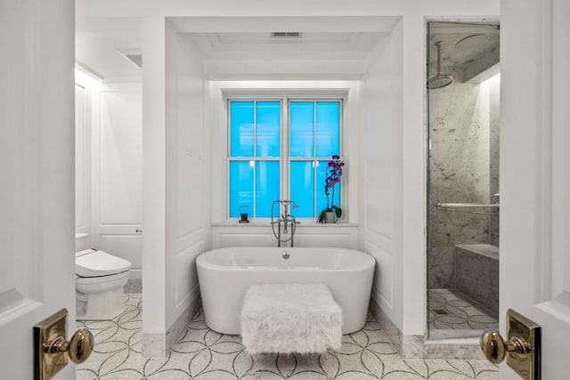 bathroom featuring tile patterned flooring, toilet, a freestanding tub, visible vents, and a stall shower