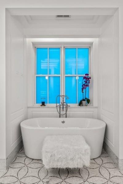 bathroom featuring visible vents and a soaking tub