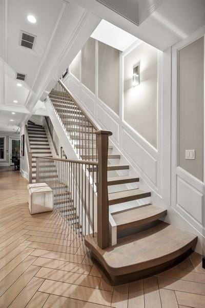 stairway featuring visible vents, recessed lighting, and a decorative wall