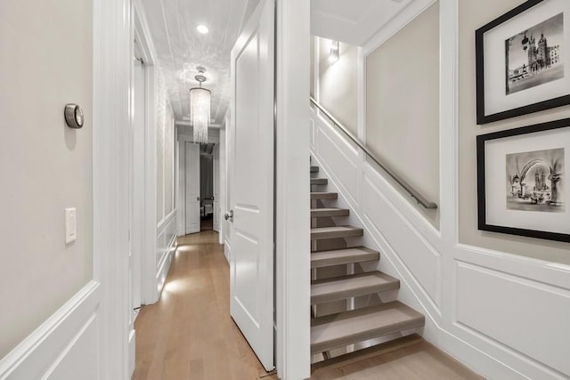 stairway featuring a wainscoted wall, a decorative wall, recessed lighting, and wood finished floors