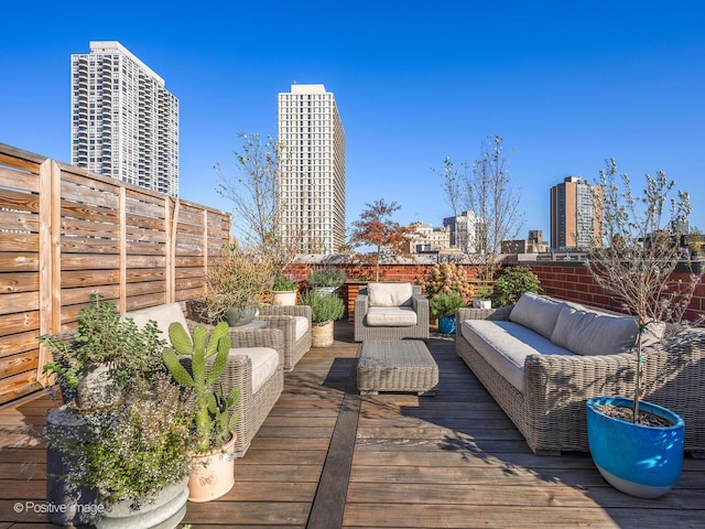 deck featuring a fenced backyard, outdoor lounge area, and a city view