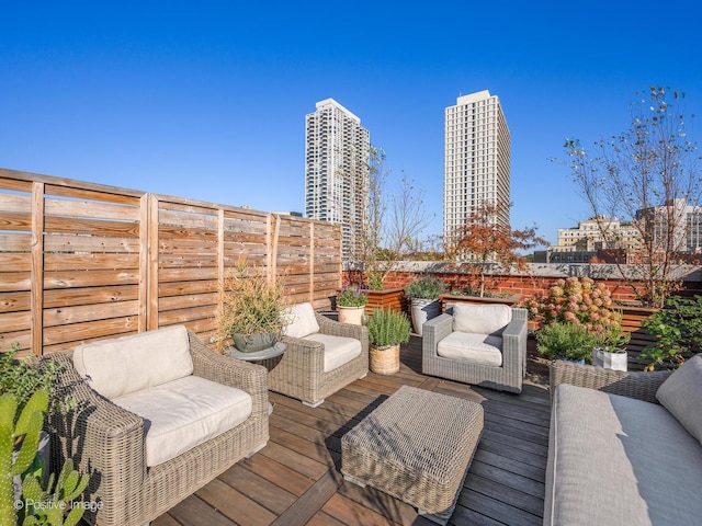 wooden terrace with a fenced backyard and outdoor lounge area