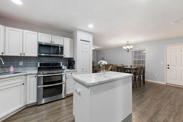 733 Florence St, Hampshire, IL 60140 - kitchen featuring appliances with stainless steel finishes, a sink, light countertops, a chandelier, and wood finished floors