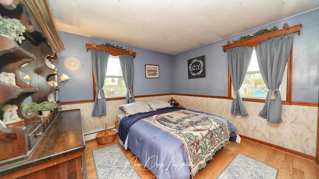 23233 W N Lakewood Ln, Lake Zurich, IL 60047 - bedroom featuring baseboard heating, wood finished floors, a wainscoted wall, lofted ceiling, and wallpapered walls
