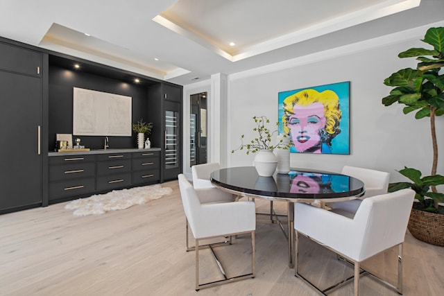 dining area featuring recessed lighting, a tray ceiling, and light wood finished floors