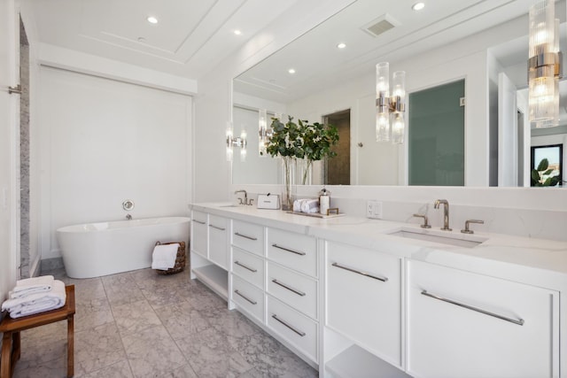 bathroom with double vanity, visible vents, a freestanding tub, a sink, and marble finish floor