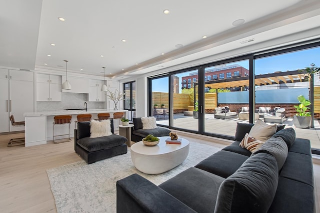 living room featuring recessed lighting, a raised ceiling, light wood finished floors, and visible vents