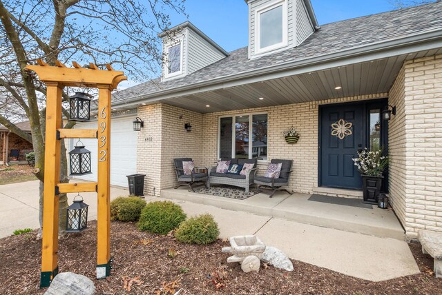 6932 Westview Dr, Oak Forest, IL 60452 - property entrance featuring brick siding, an attached garage, roof with shingles, and an outdoor hangout area