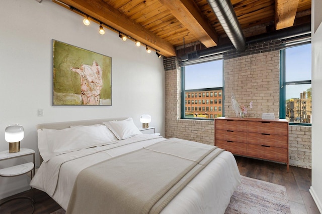 bedroom featuring track lighting, dark wood-style flooring, beam ceiling, brick wall, and wooden ceiling