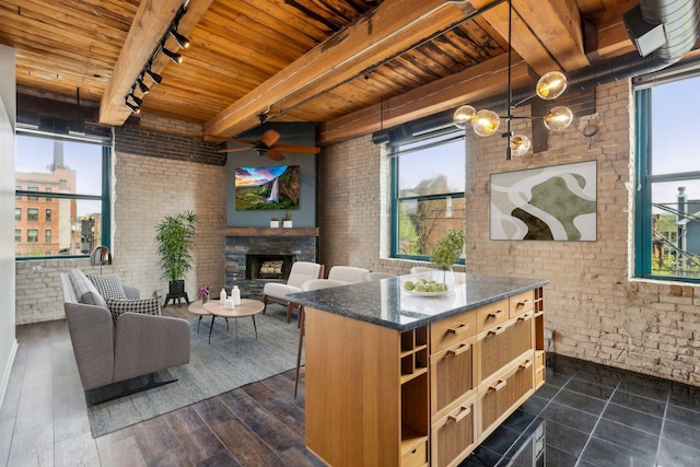 interior space with wooden ceiling, track lighting, and brick wall