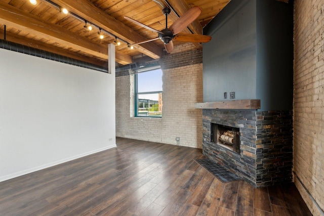 unfurnished living room featuring wood ceiling, beamed ceiling, rail lighting, and wood finished floors
