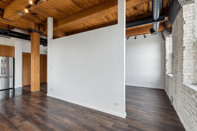 unfurnished room featuring wooden ceiling, track lighting, dark wood-style floors, and beam ceiling