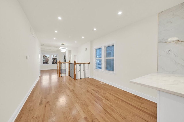interior space with baseboards, recessed lighting, and light wood-style flooring
