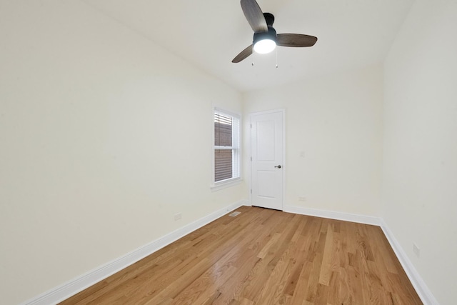 spare room featuring baseboards, visible vents, ceiling fan, and light wood-type flooring
