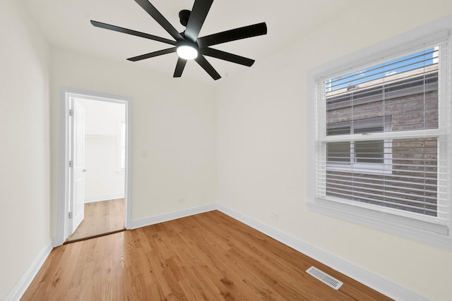 empty room with visible vents, light wood finished floors, ceiling fan, and baseboards