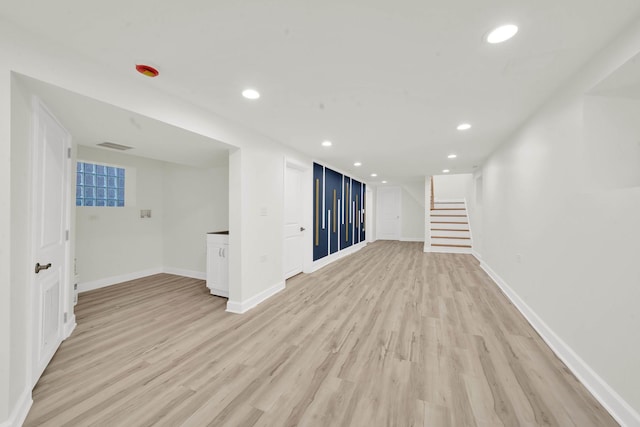 spare room with stairway, baseboards, recessed lighting, and light wood-style flooring