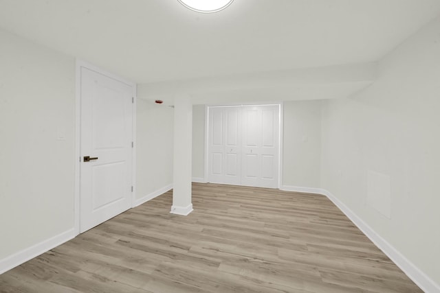 unfurnished bedroom with baseboards, light wood finished floors, and a closet