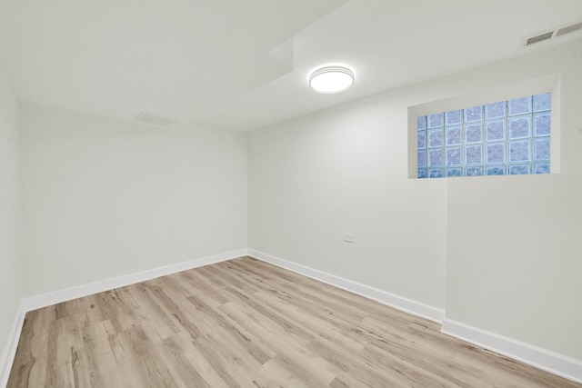 spare room with baseboards, visible vents, and light wood finished floors