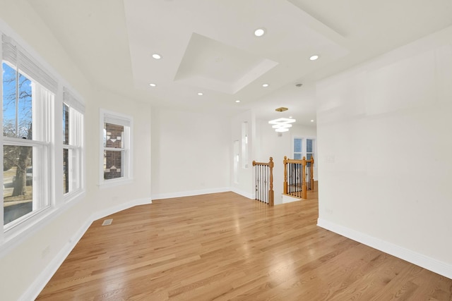 unfurnished room with a skylight, recessed lighting, and light wood-style flooring
