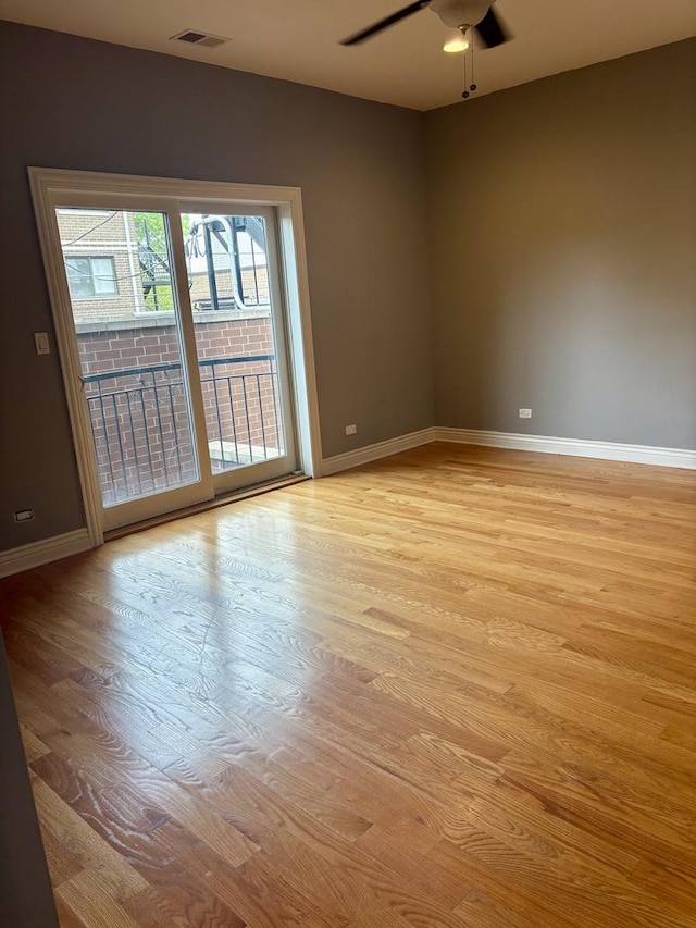 unfurnished room featuring a ceiling fan, light wood-style flooring, and baseboards