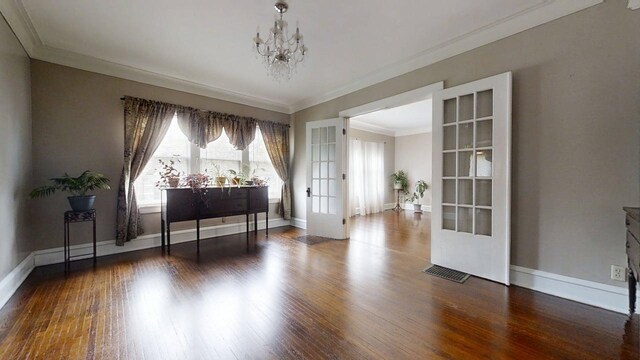 229 E Jefferson St, Arcola, IL 61910 - living area with french doors, crown molding, a chandelier, wood finished floors, and baseboards