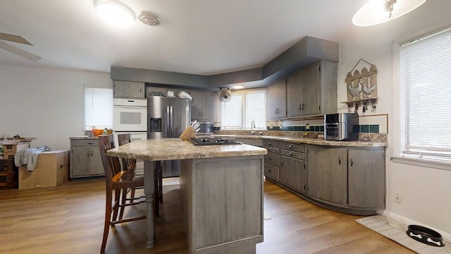 229 E Jefferson St, Arcola, IL 61910 - kitchen with appliances with stainless steel finishes, healthy amount of natural light, light wood-style flooring, and a ceiling fan