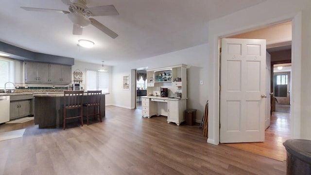 229 E Jefferson St, Arcola, IL 61910 - kitchen featuring wood finished floors, ceiling fan, a kitchen bar, light countertops, and baseboards