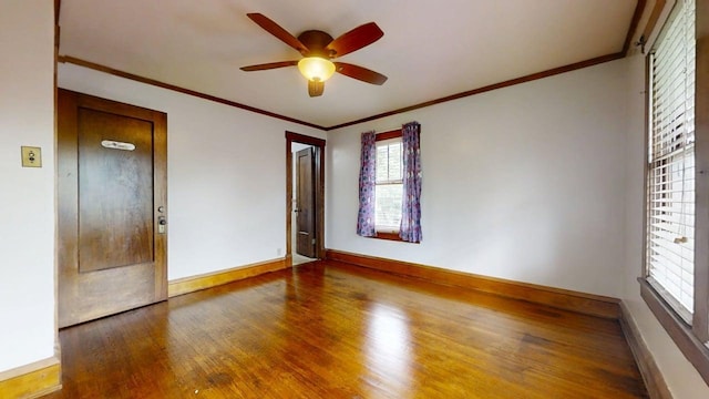 229 E Jefferson St, Arcola, IL 61910 - empty room featuring wood finished floors, ceiling fan, baseboards, and crown molding