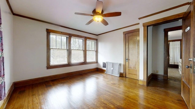 229 E Jefferson St, Arcola, IL 61910 - unfurnished bedroom featuring crown molding, baseboards, wood finished floors, and ceiling fan