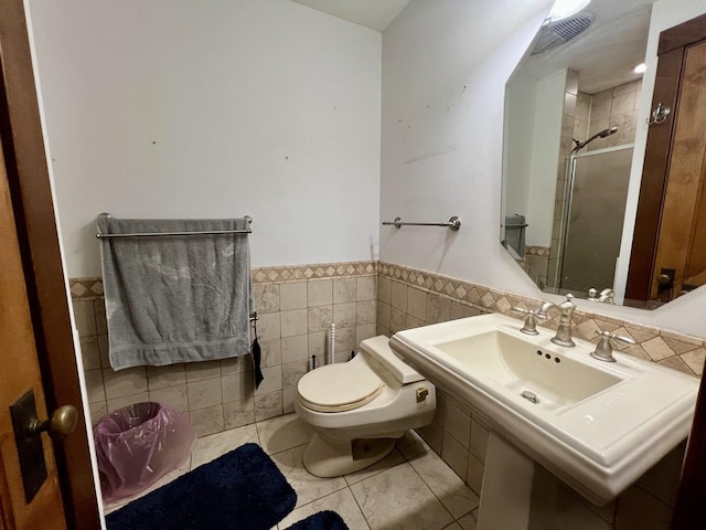 229 E Jefferson St, Arcola, IL 61910 - full bath with a stall shower, tile walls, a wainscoted wall, toilet, and tile patterned floors