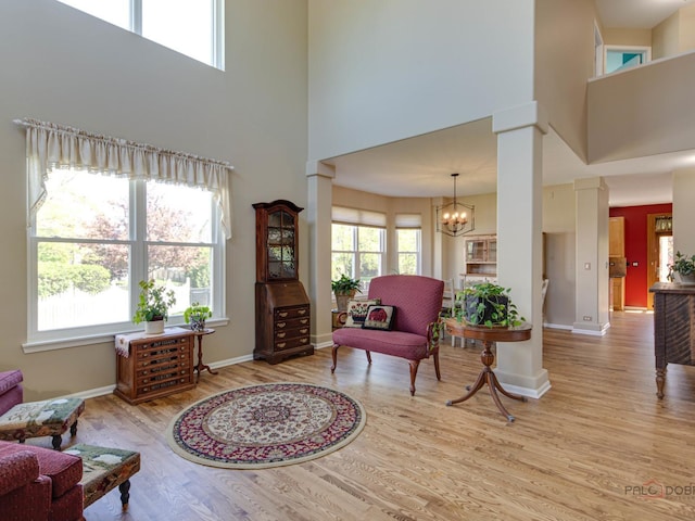 1341 N Home Ct, Palatine, IL 60074 - living area featuring a towering ceiling, wood finished floors, ornate columns, baseboards, and a chandelier