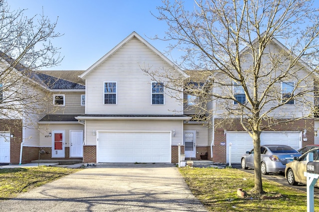 view of front facade with a garage, driveway, and brick siding
