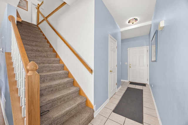 stairs featuring baseboards and tile patterned flooring