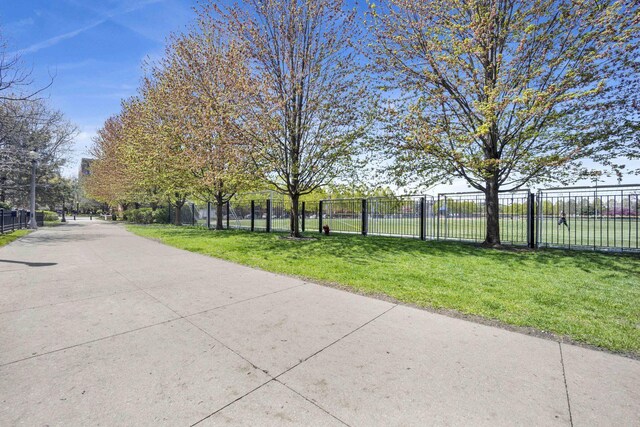 surrounding community with fence and a yard