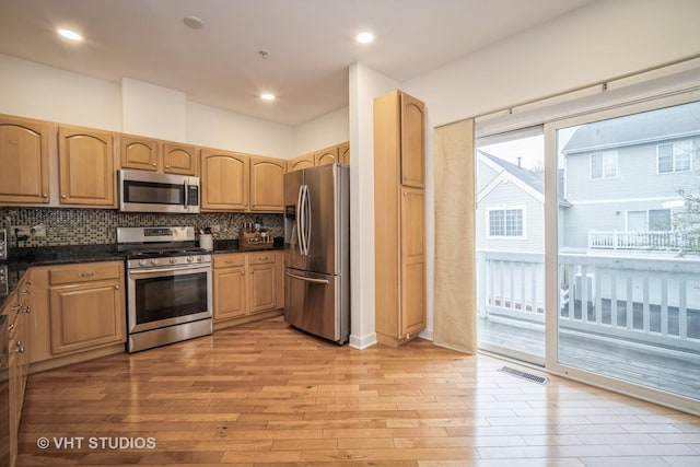 kitchen featuring backsplash, visible vents, light wood-style floors, stainless steel appliances, and recessed lighting