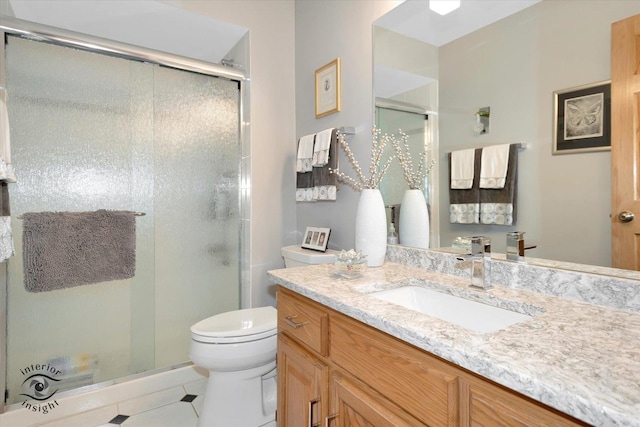 full bathroom featuring vanity, a stall shower, and toilet
