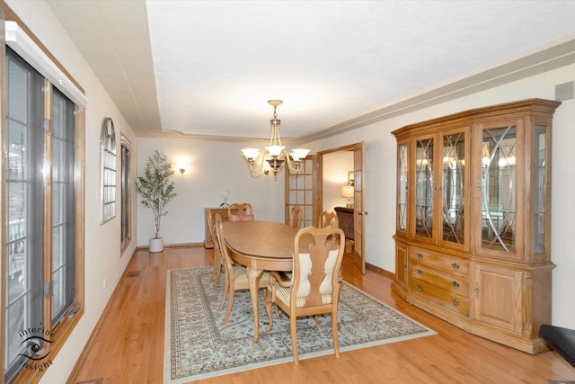 dining room featuring baseboards, a notable chandelier, visible vents, and light wood-style floors