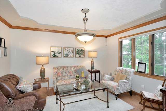 living area featuring crown molding, baseboards, and wood finished floors